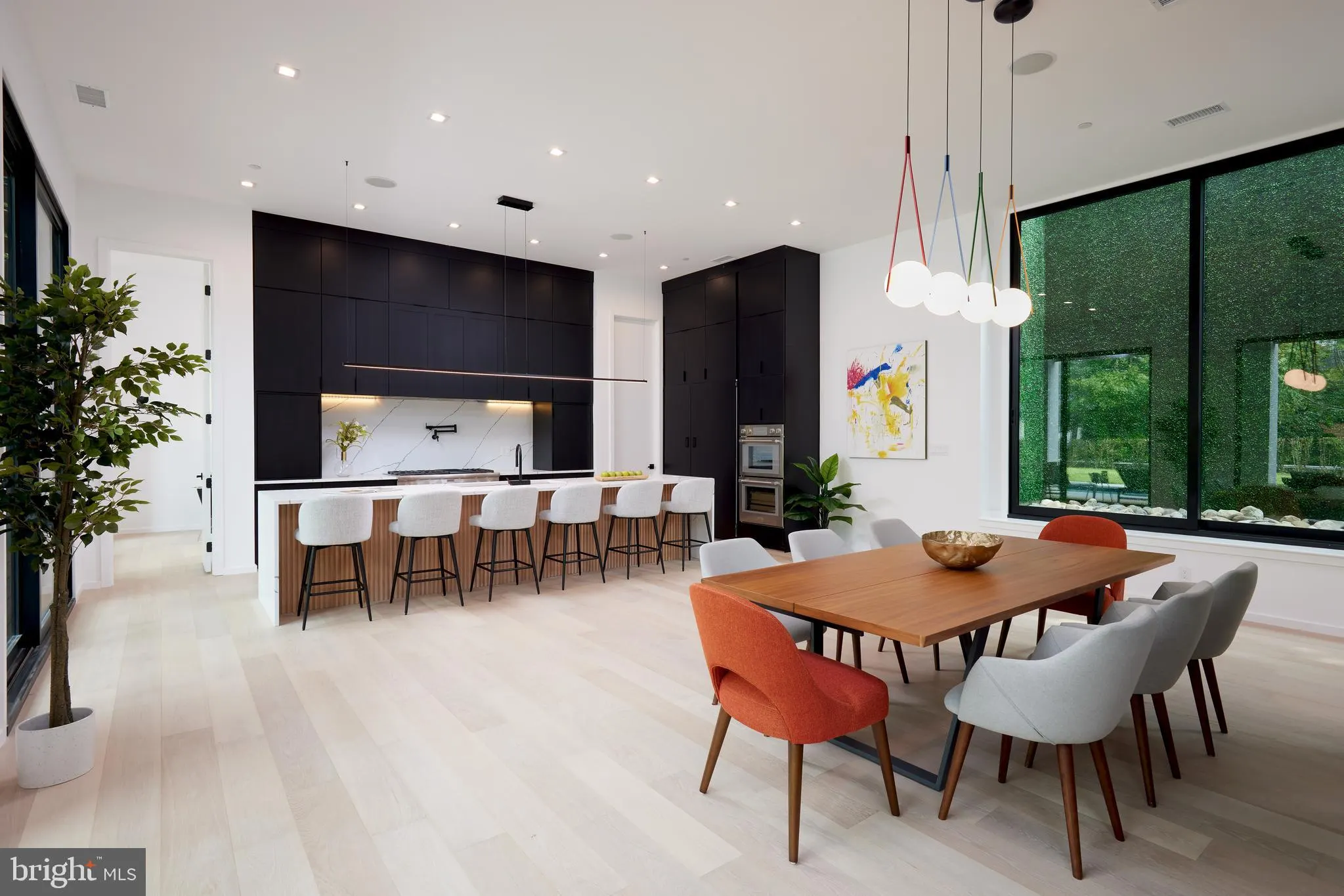 Kitchen island with black cabinetry, a waterfall stone counter, and bar stools