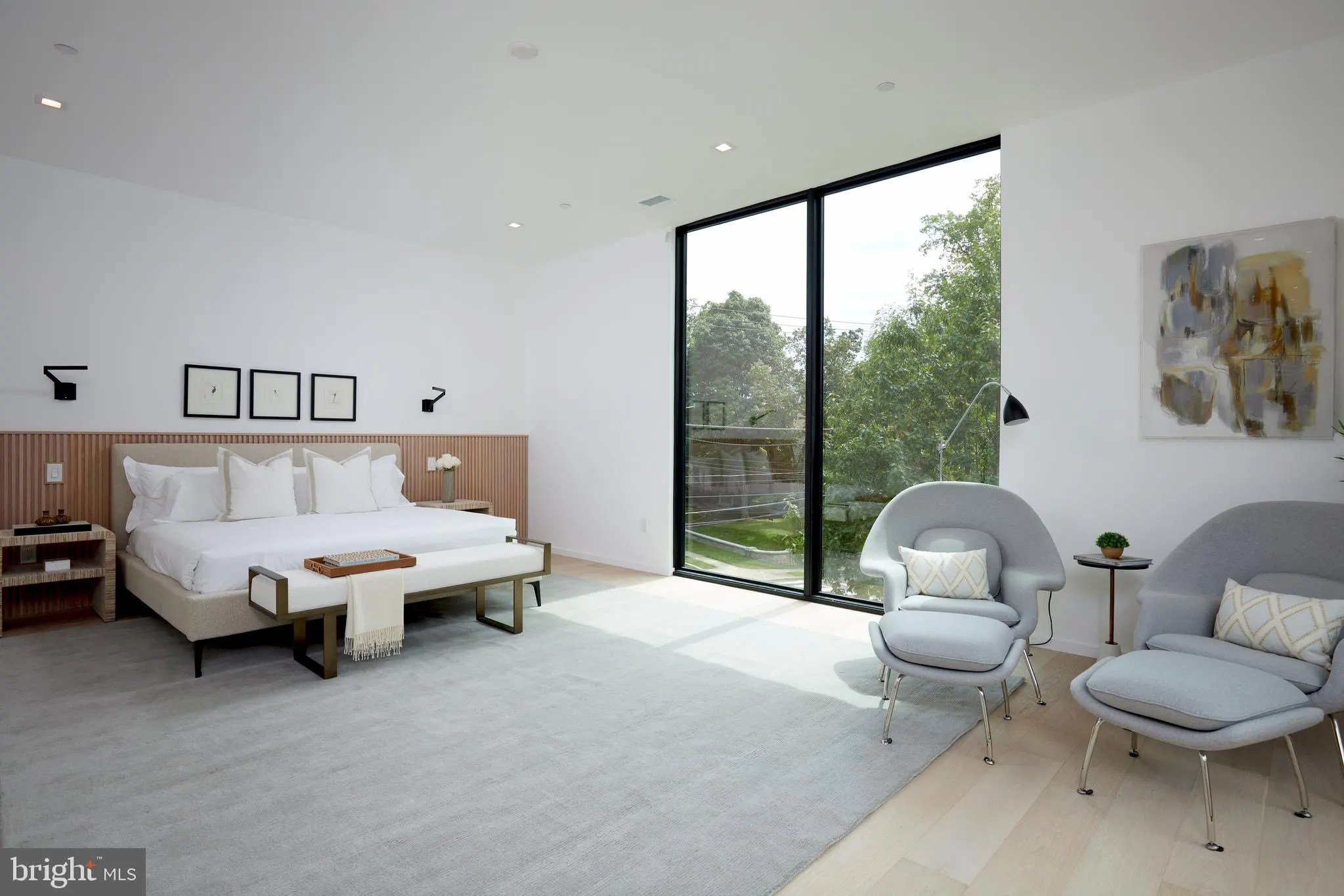 Primary sitting area with lounge chairs and a sliding door to the deck