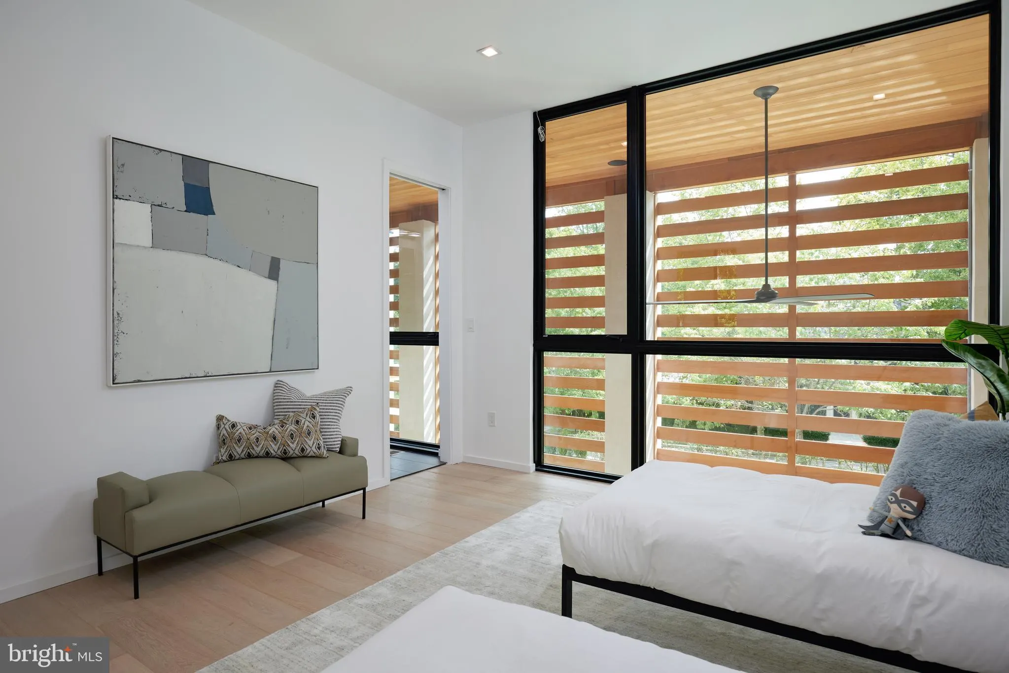 Guest bedroom with green accents and a slat-screened window