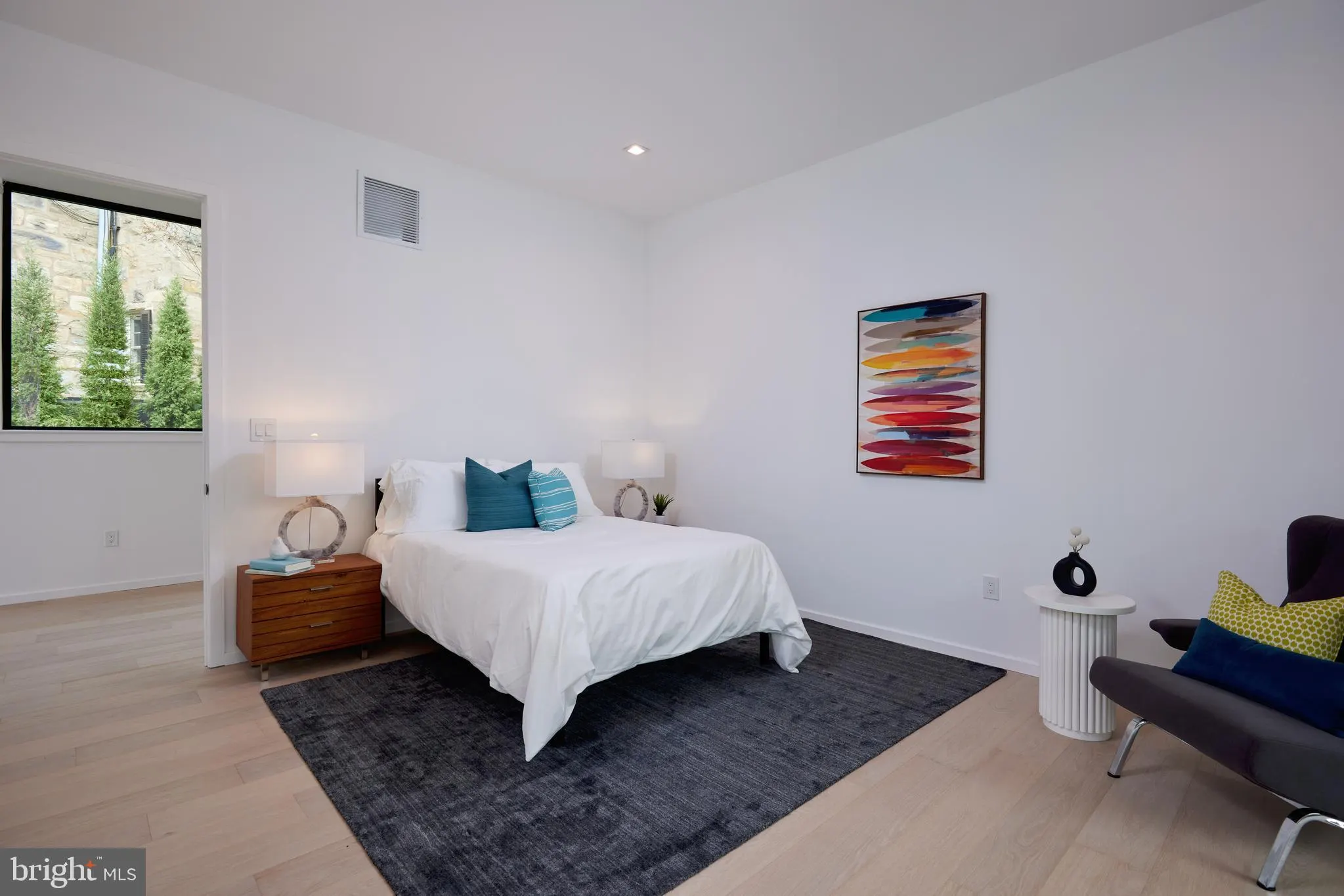 Bedroom with a black daybed and automated window shades