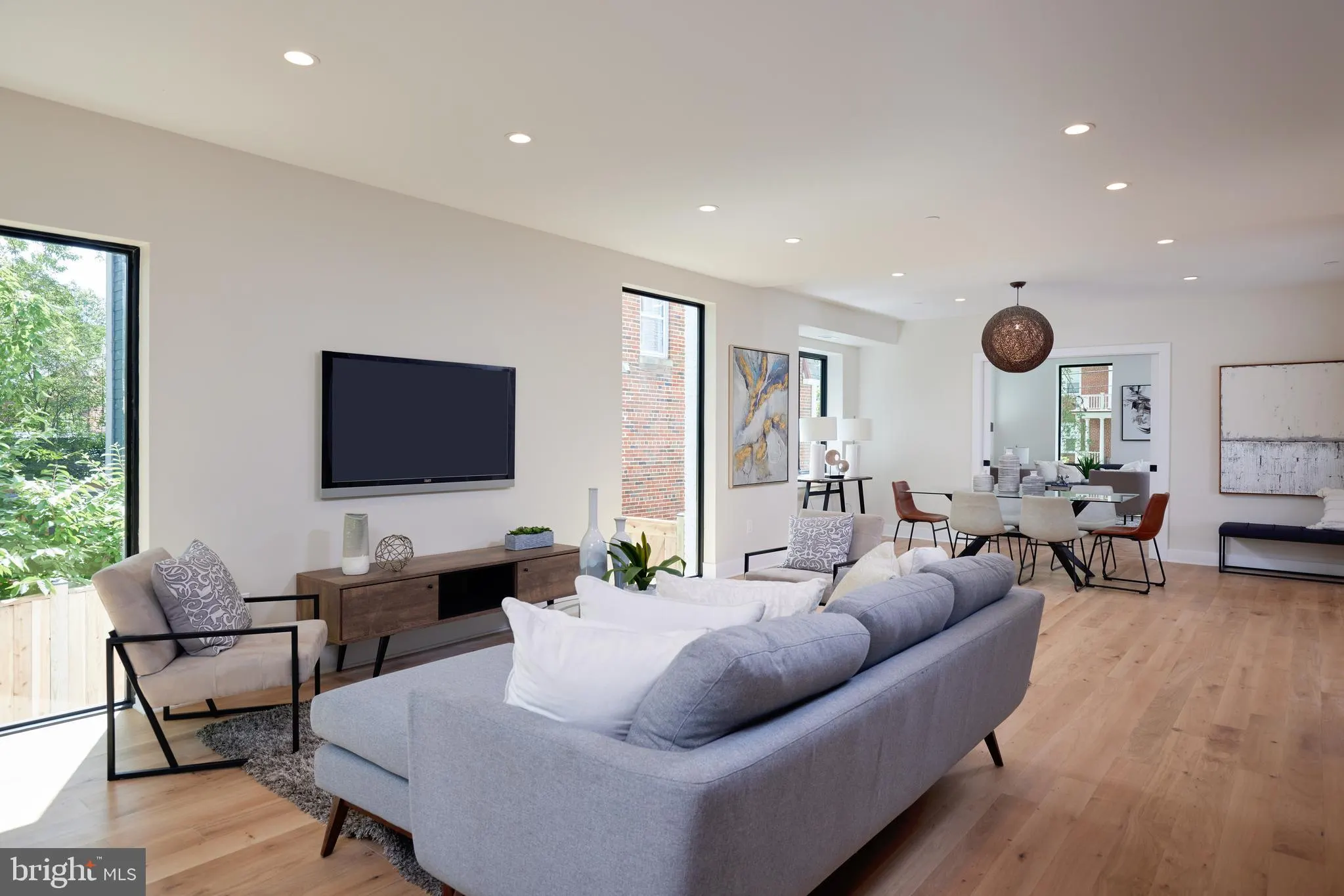 Open-concept living area with gray sofa and wood entertainment console