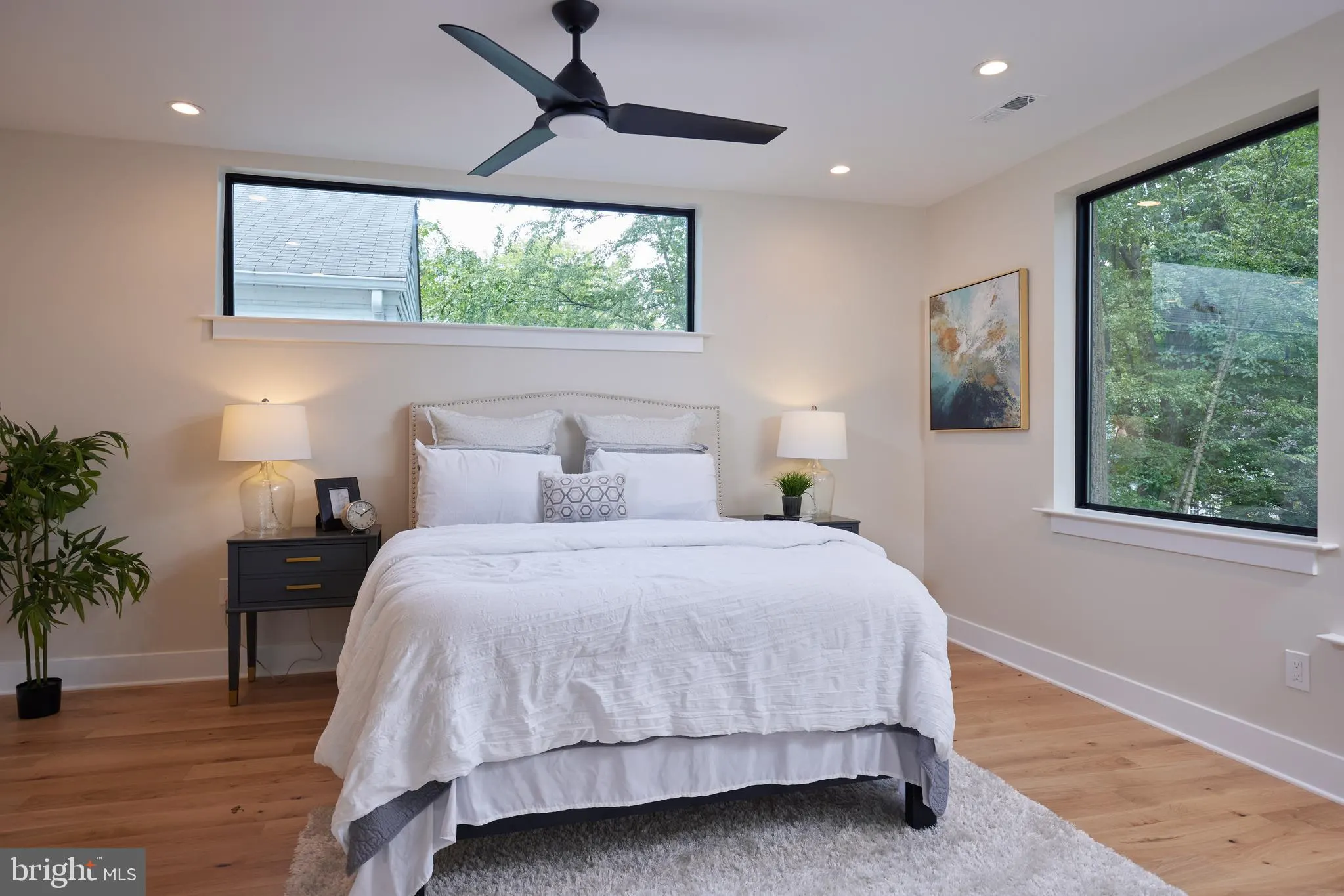 Primary bedroom with upholstered headboard and black nightstands
