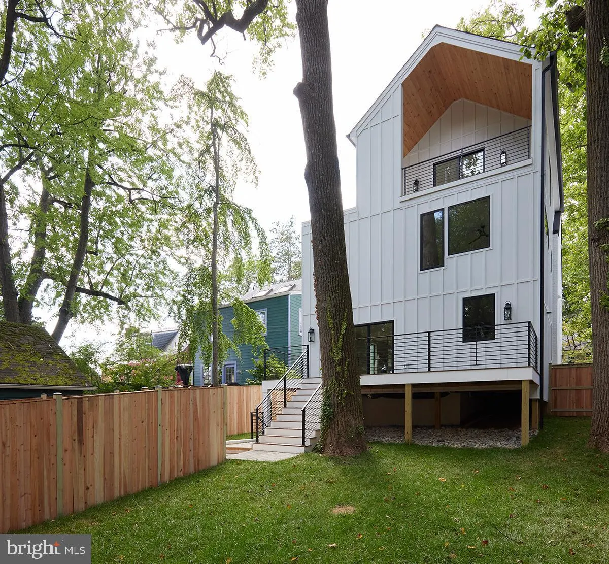 Modern white house with board and batten siding and metal railings