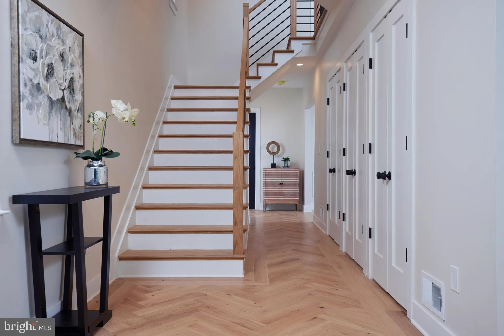 Hallway with wooden staircase and white closet doors