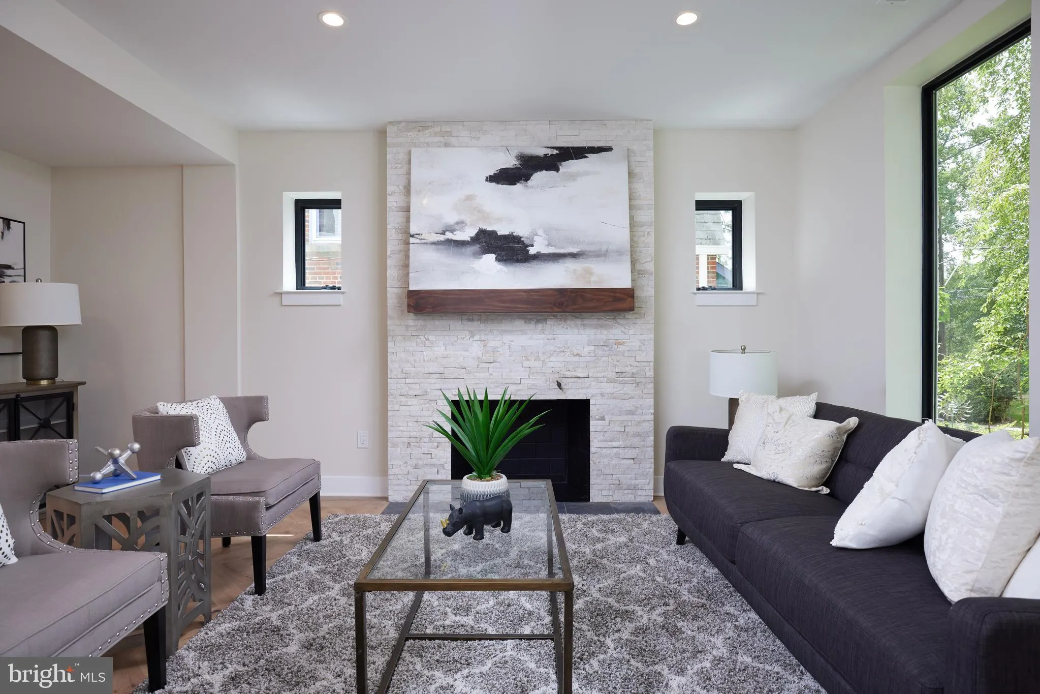 Living room with white brick fireplace and black sofa