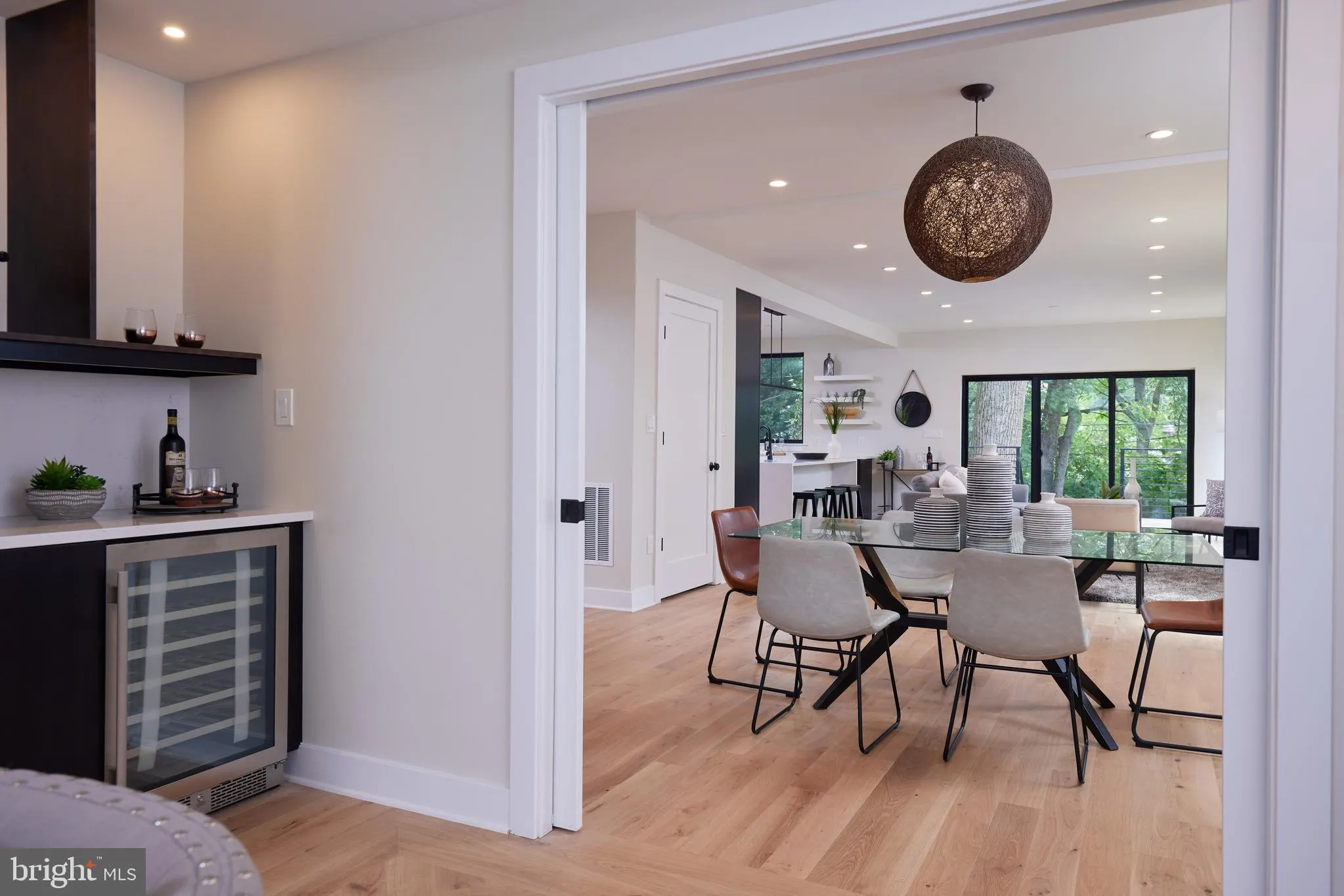 Dining area with glass table and mixed seating, kitchen visible