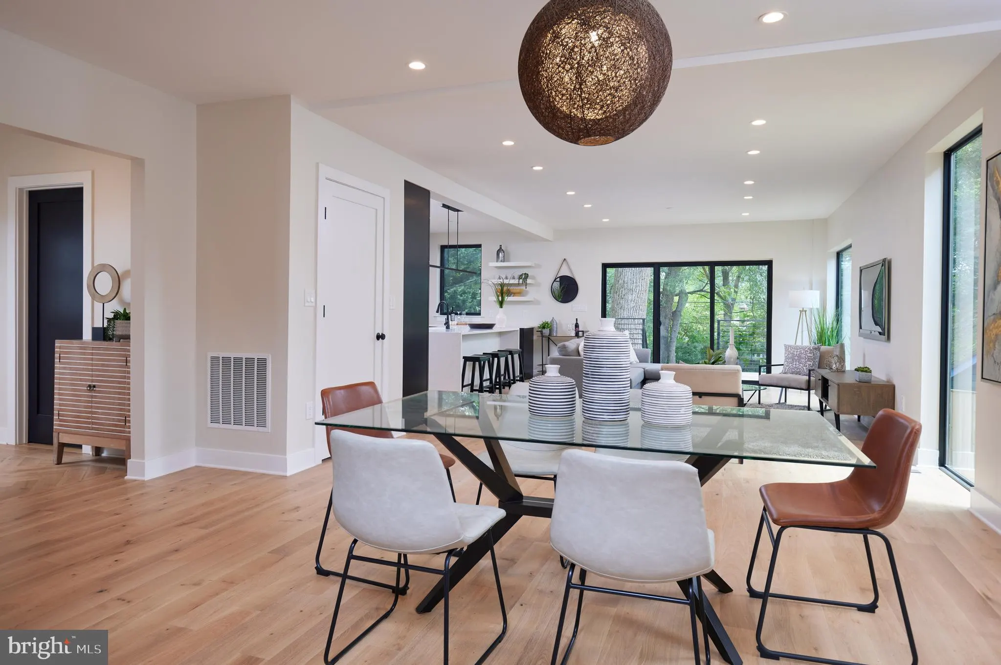 Dining room with glass-top table and woven pendant light fixture