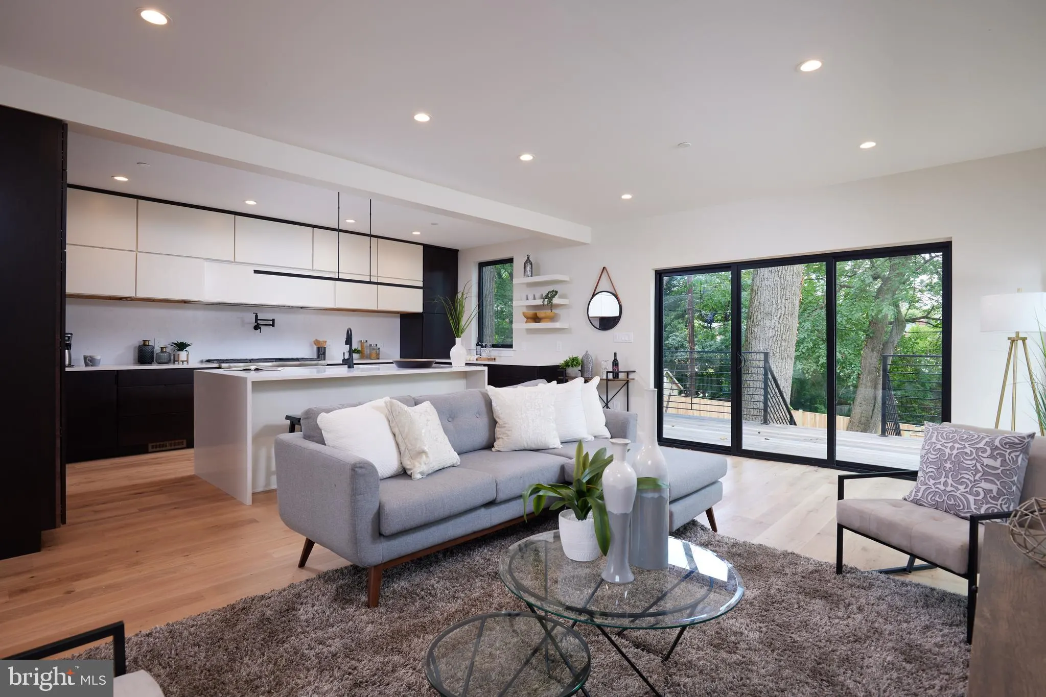 Kitchen and living space with black cabinetry and gray seating