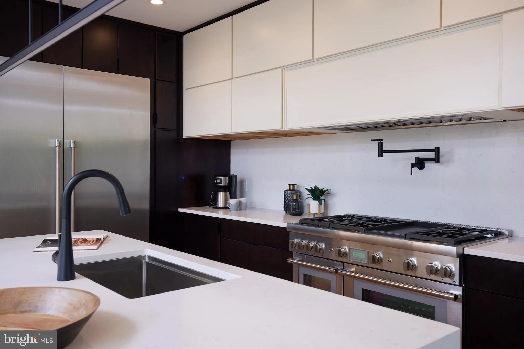 Kitchen detail with dual ovens, gas range, and white countertops