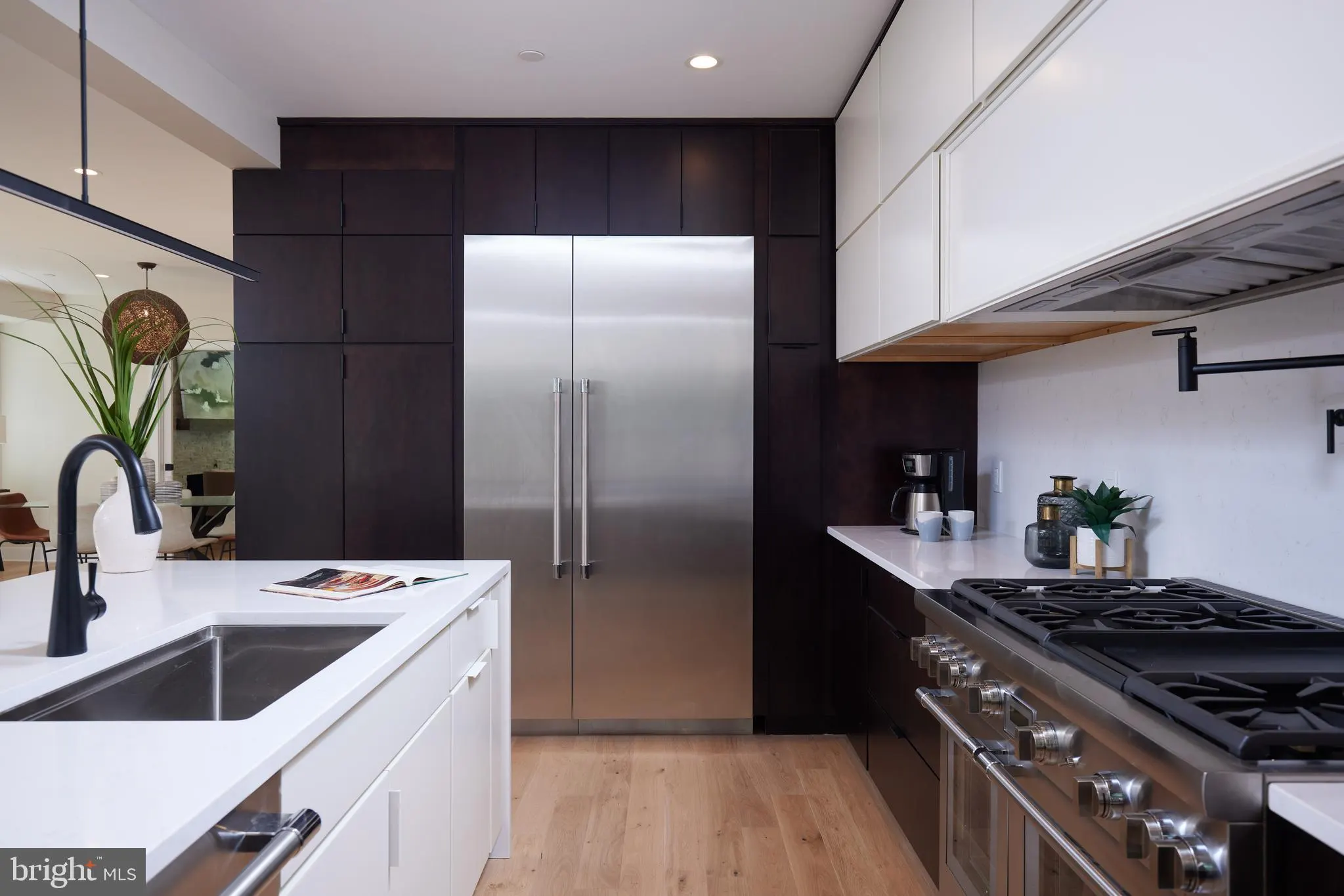 Kitchen with black cabinetry, stainless steel refrigerator, and professional range