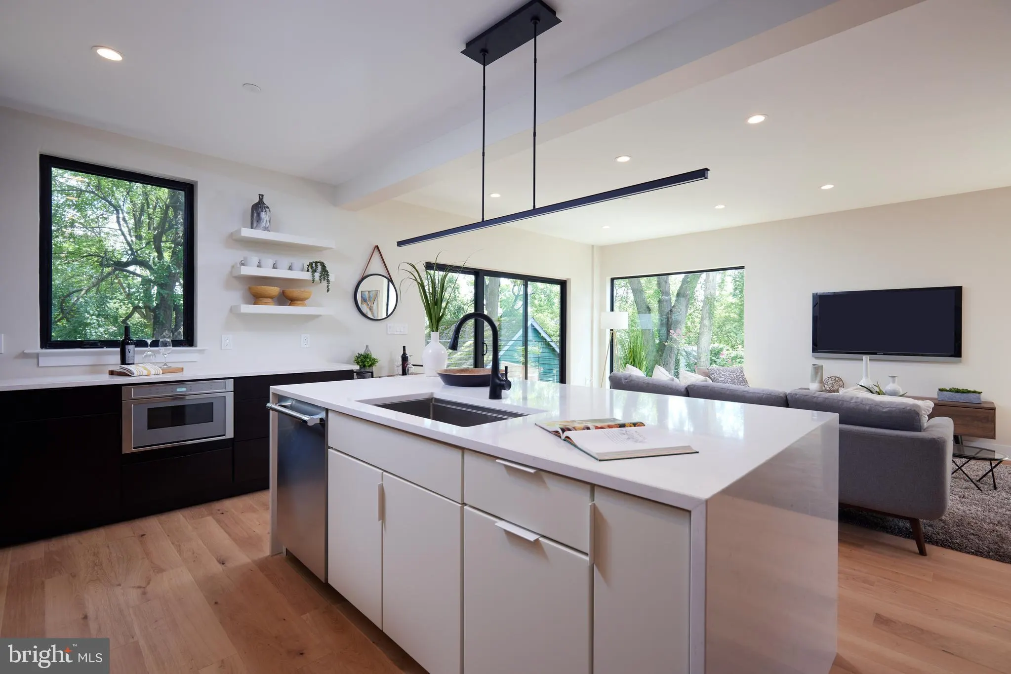 Open concept kitchen and living room with island and television
