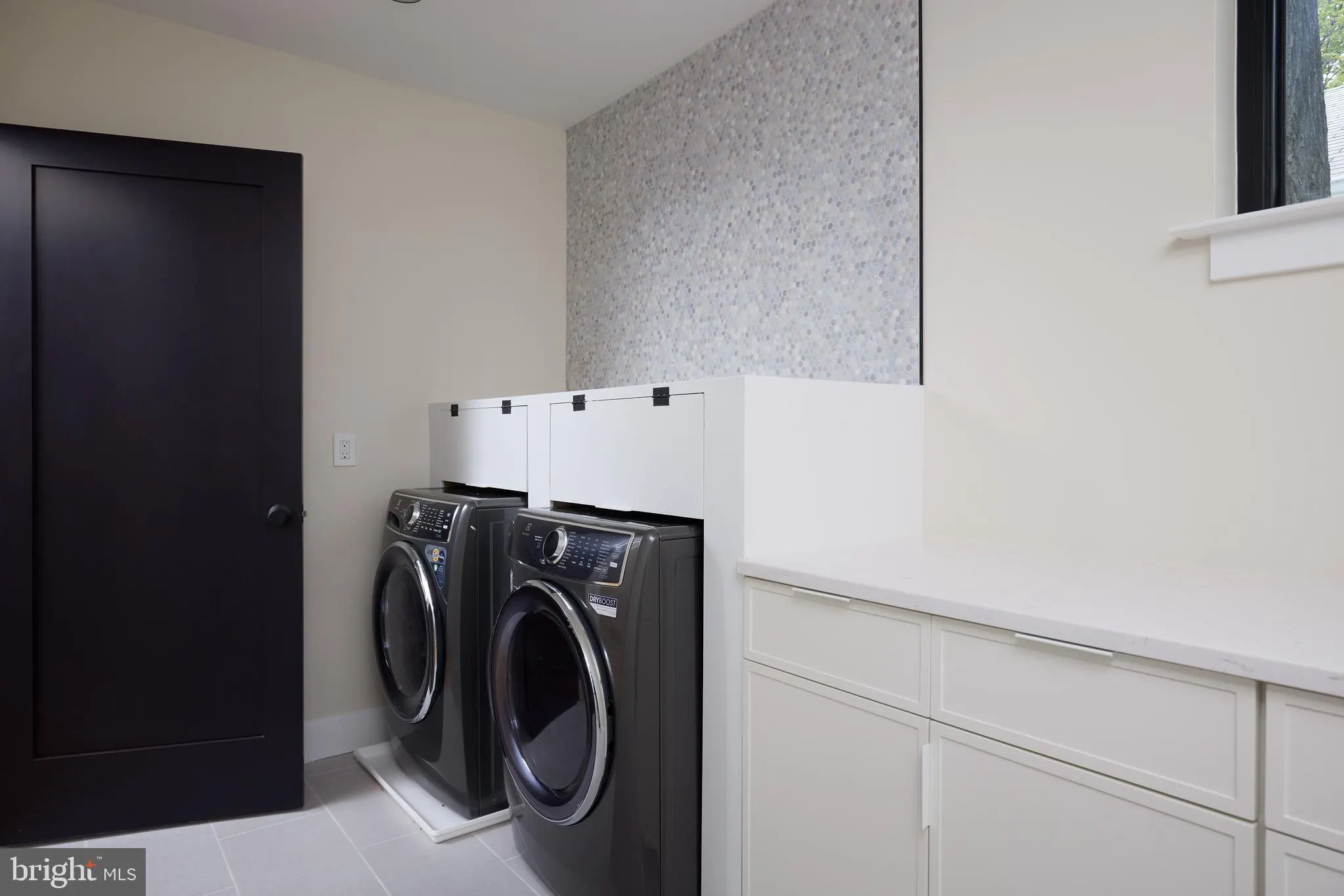 Laundry room with black front-load washer and dryer units