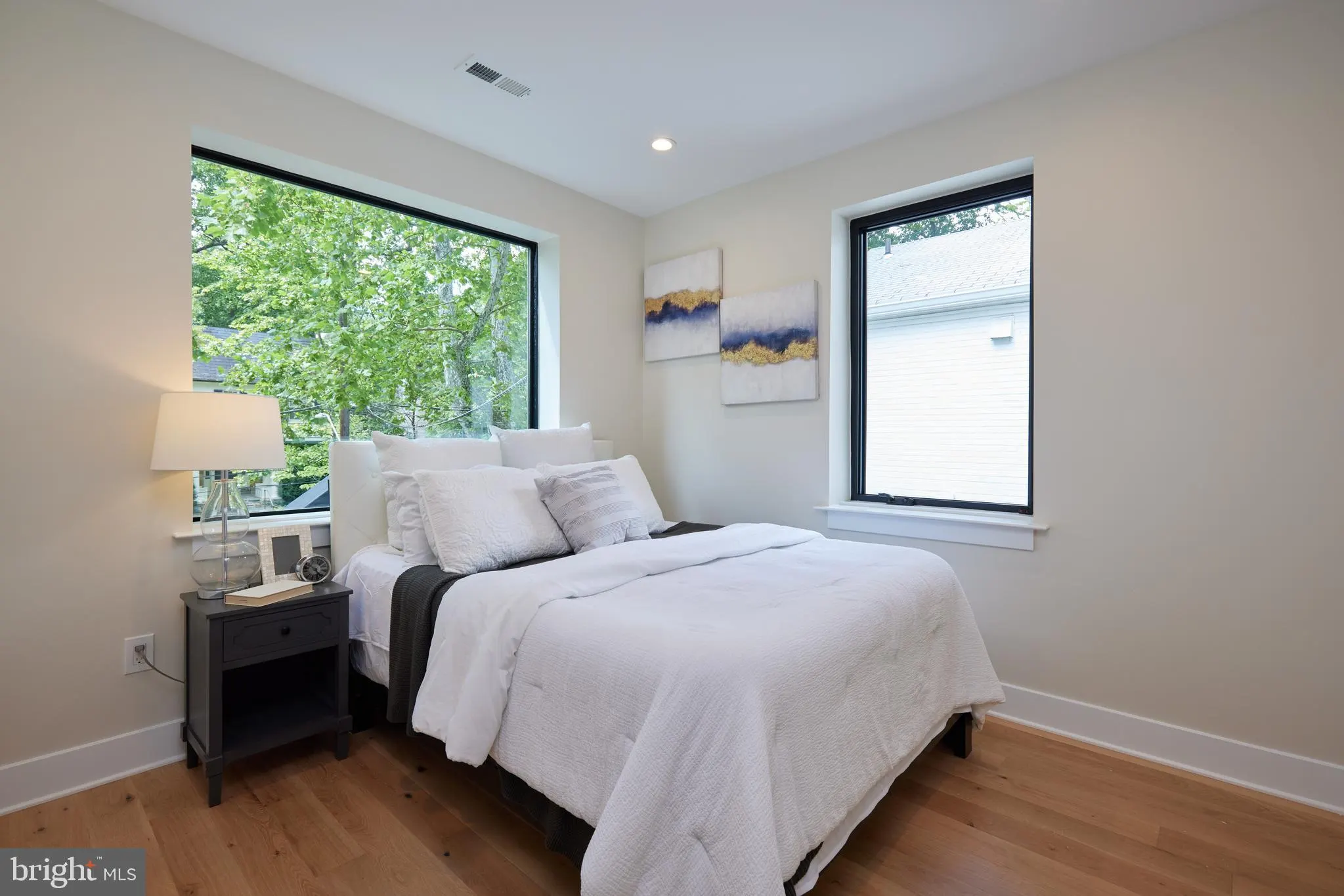 Secondary bedroom with queen bed and two large windows