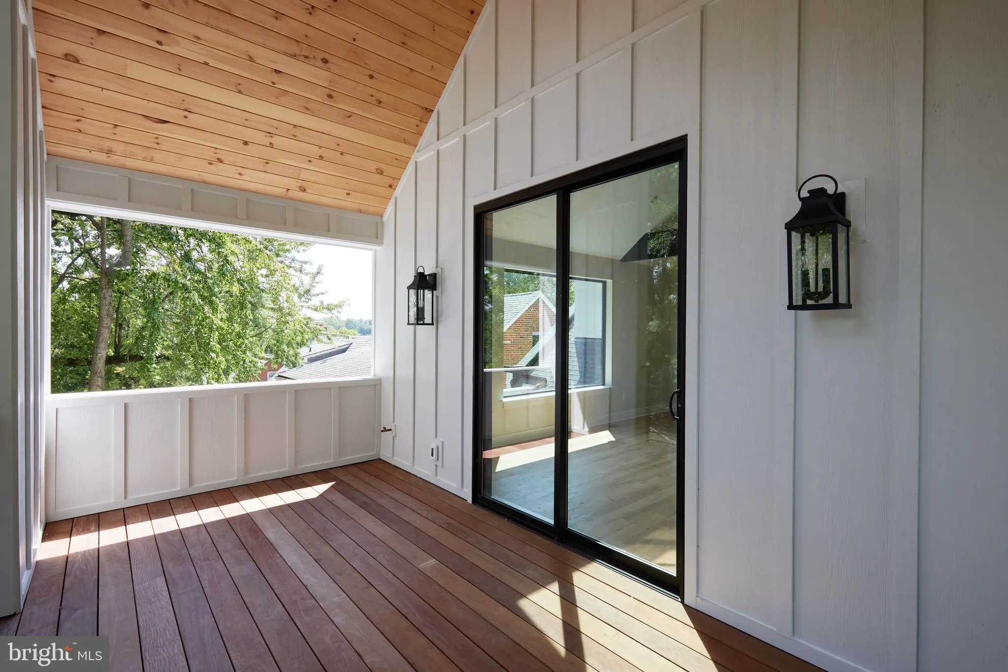 Screened porch with wood ceiling and black framed glass doors
