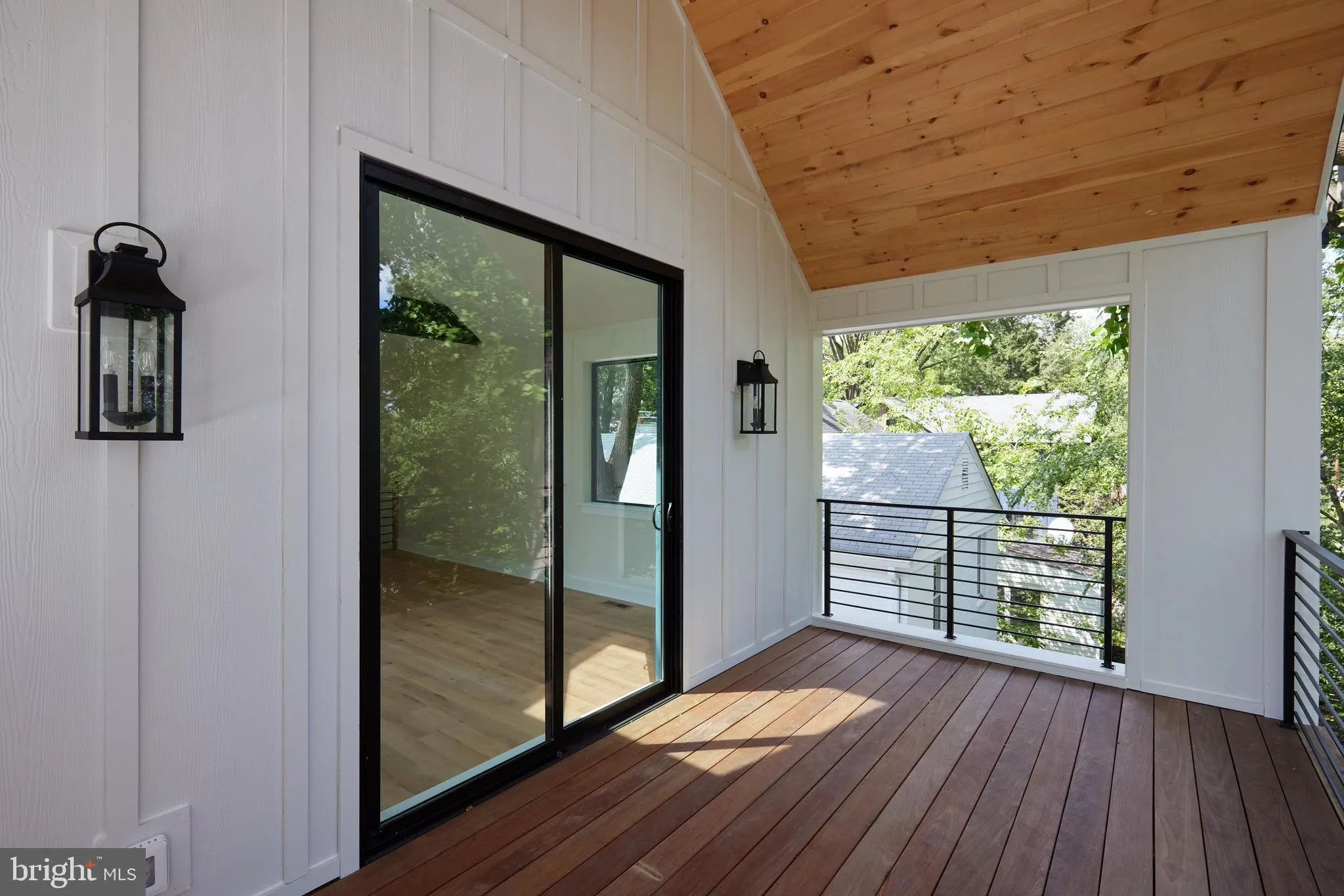Covered deck with wood ceiling and metal railing