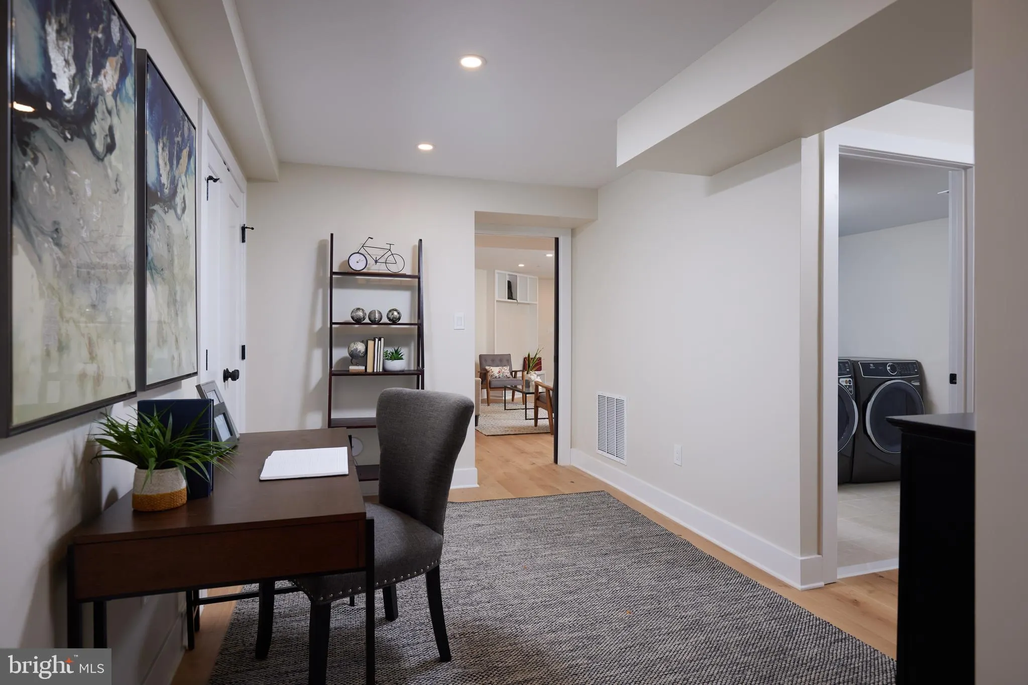 Basement office space with desk and adjacent laundry room