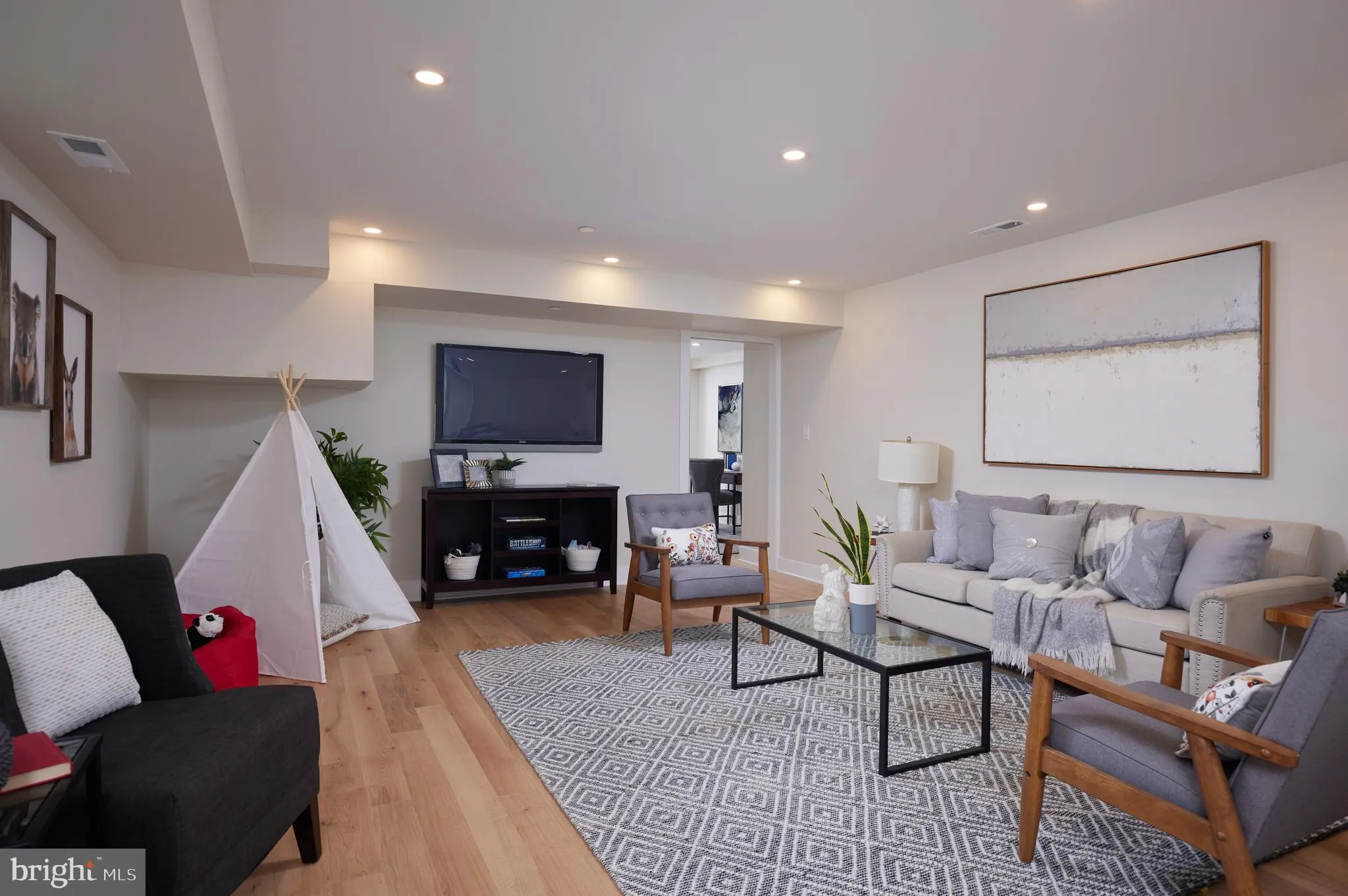 Family room with gray sofa, TV, and wood flooring