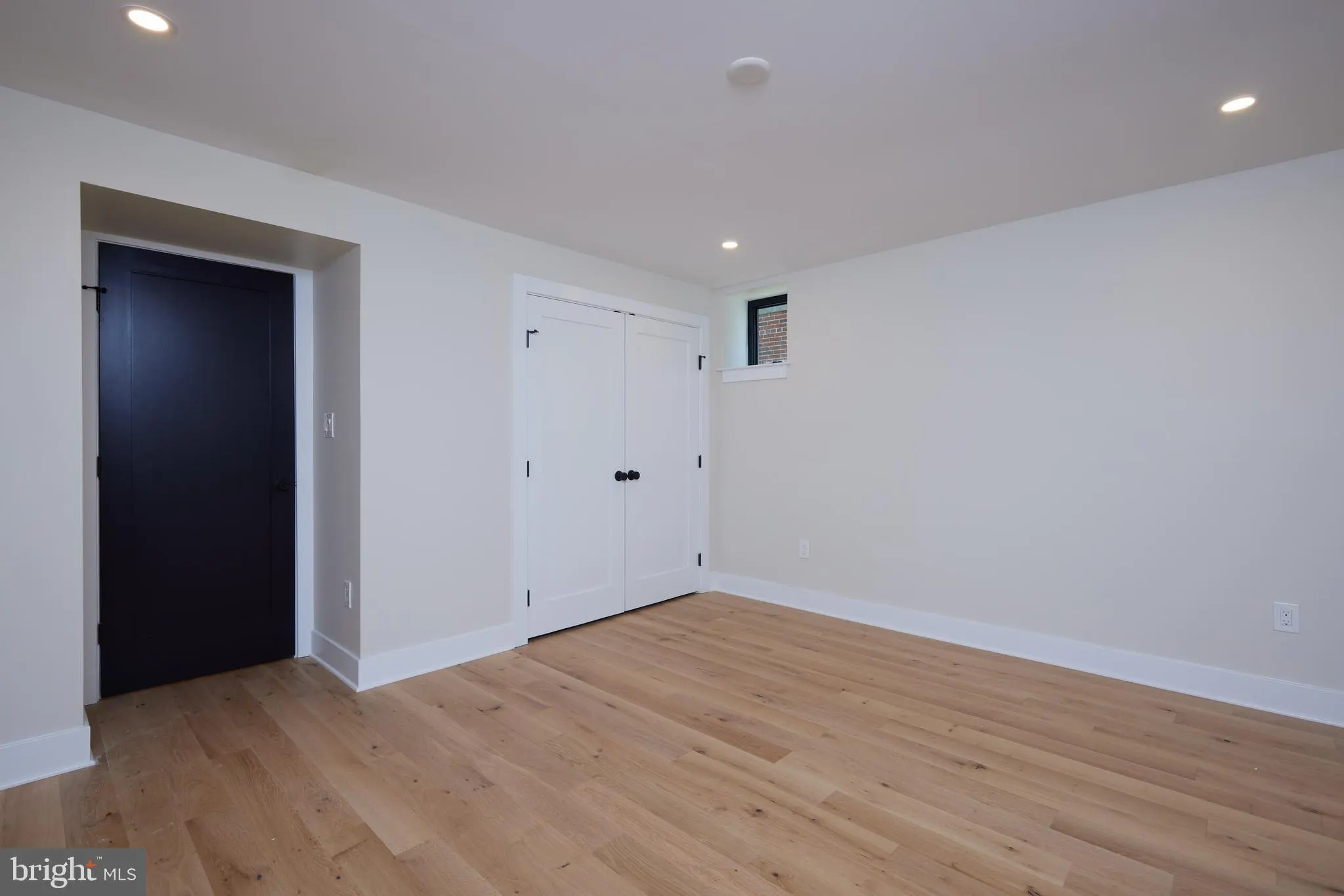 Bedroom with closet doors and hardwood flooring