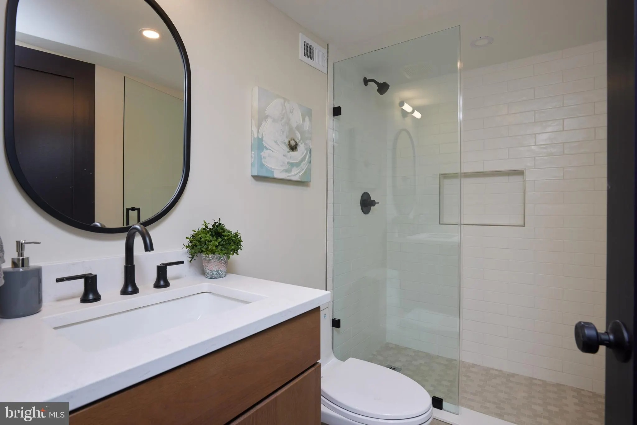 Bathroom with white subway tile shower and wood vanity