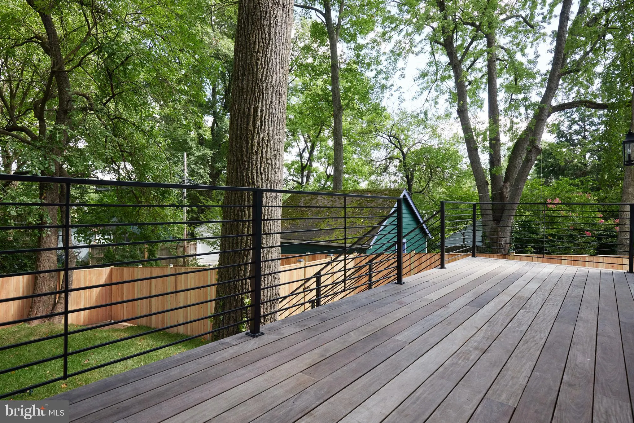 Composite deck with cable railing and mature trees