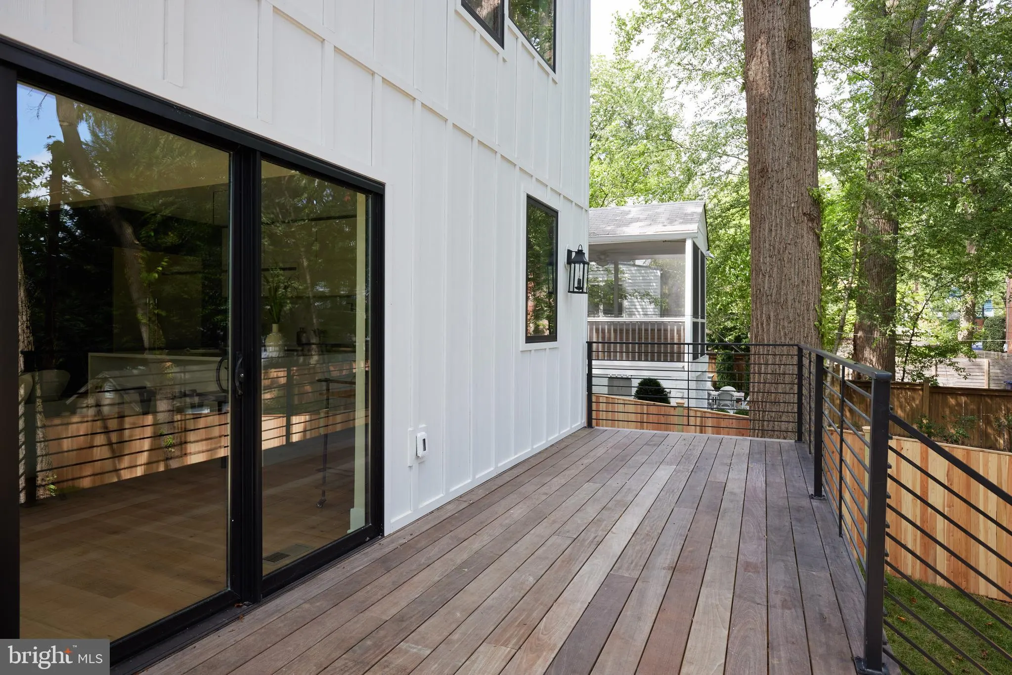 Composite deck with black framed glass doors and metal railing