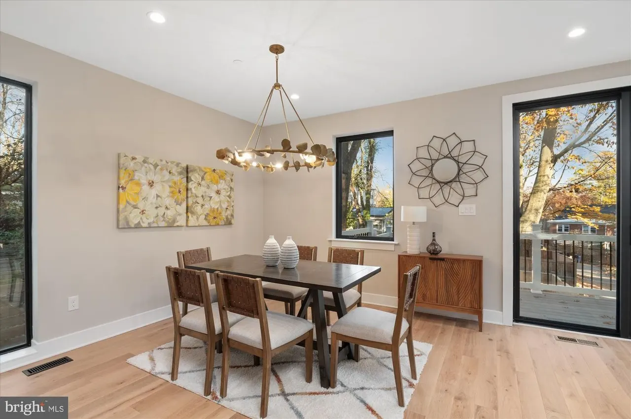 Dining room with wood table, brass chandelier, hardwood floors