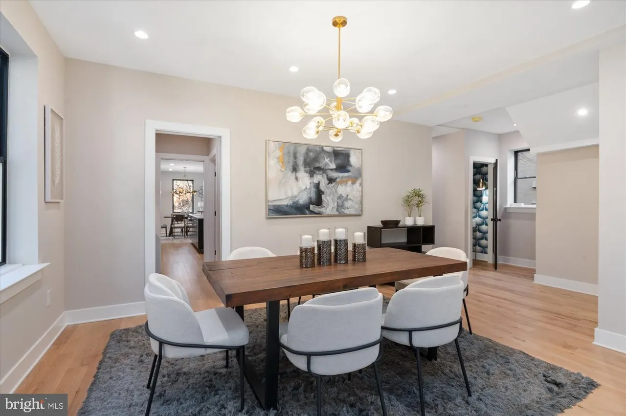 Formal dining room with wood table, modern gold chandelier, hardwood floors