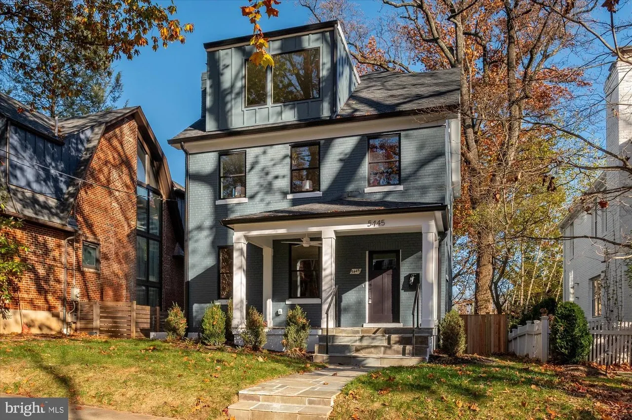 Three-story modern home with gray siding and white front porch