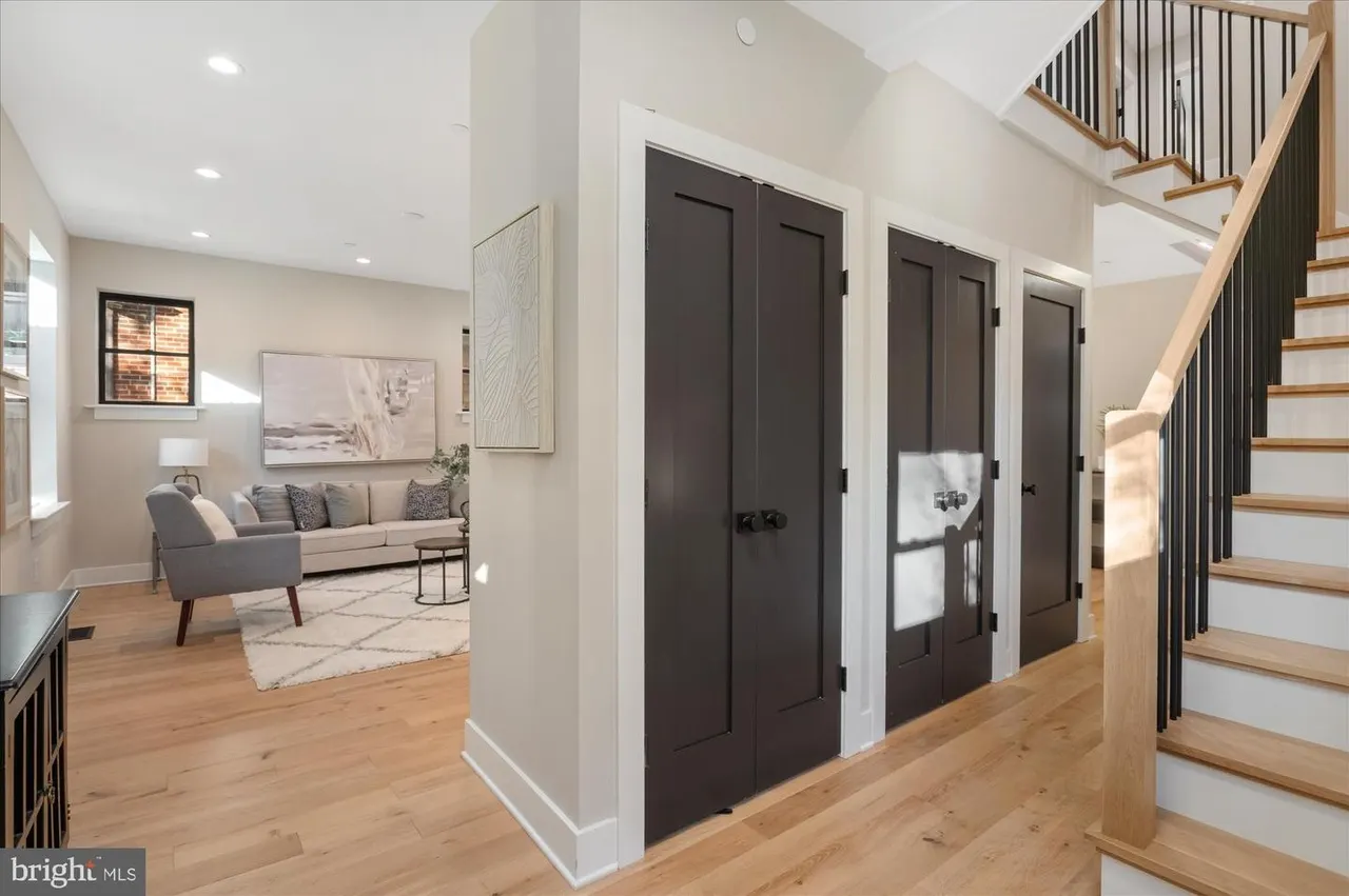 Open foyer and living room with gray sofa and natural light