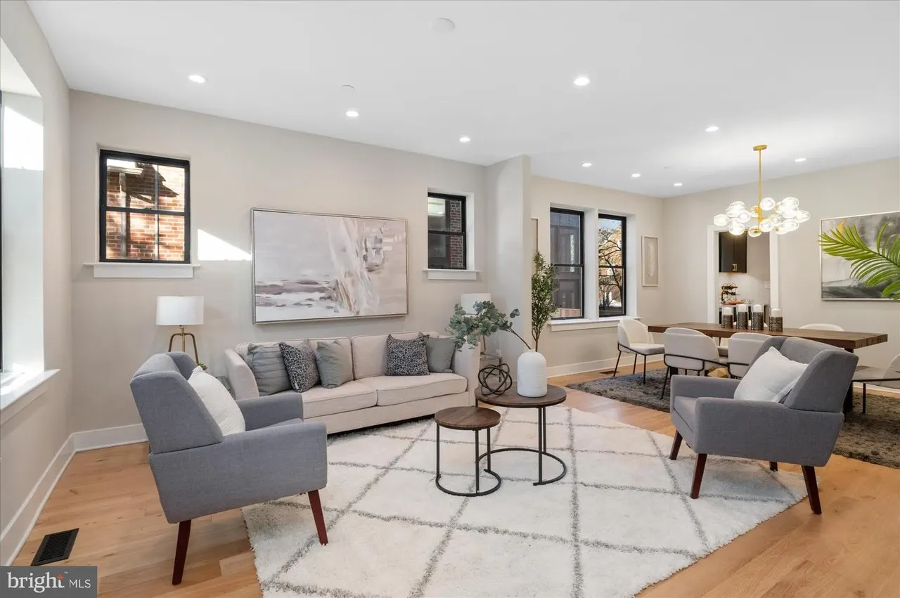 Modern living room with gray furniture, pendant lighting, and wood floors
