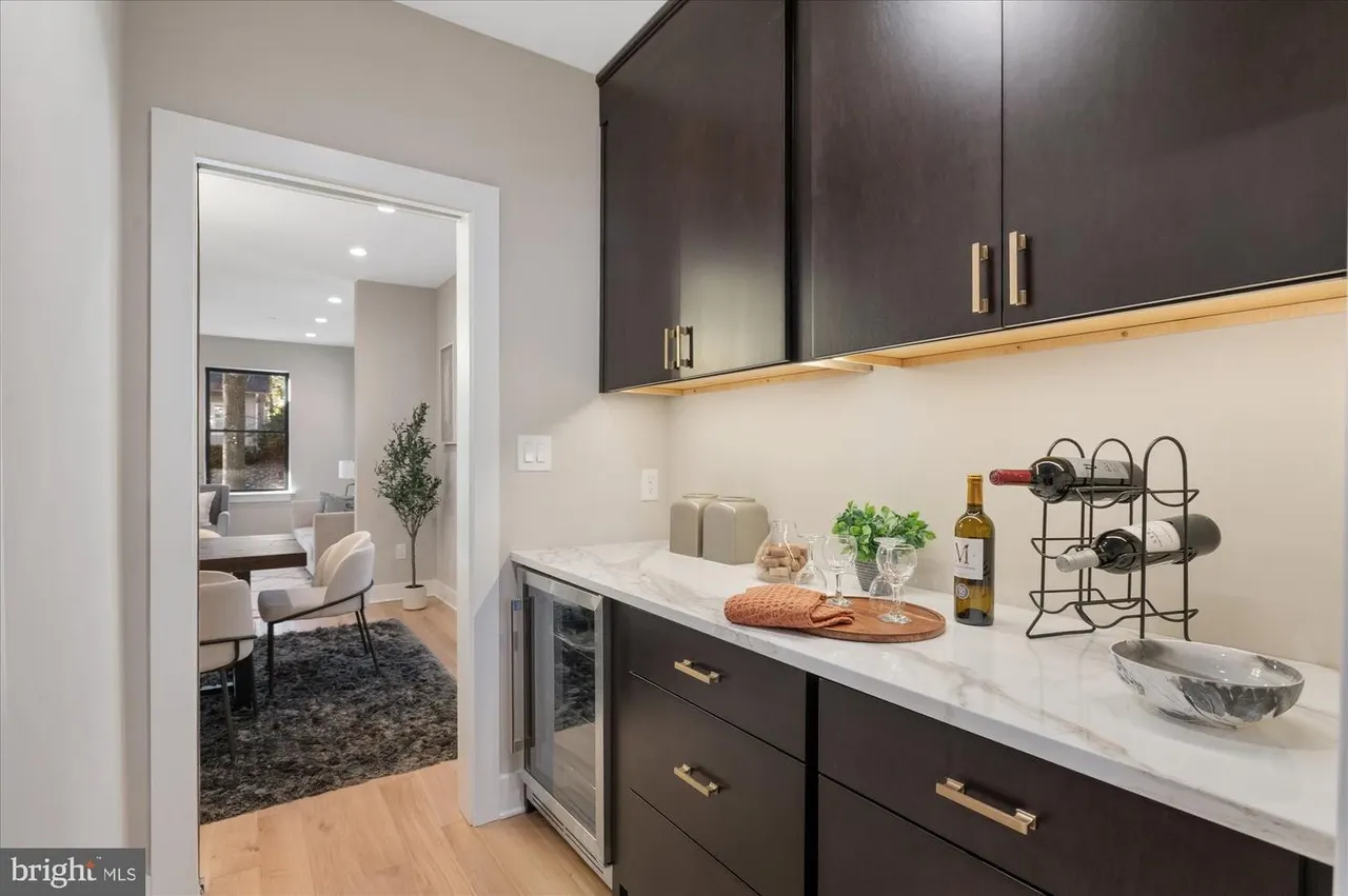 Butler's pantry with dark cabinetry, white countertop, and wine storage