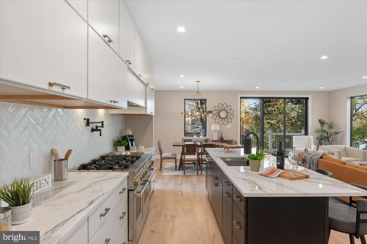 Kitchen and dining area with white cabinetry and herringbone backsplash