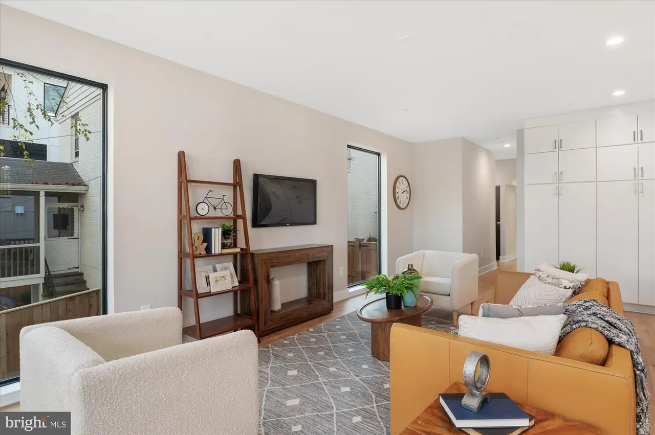 Primary suite sitting room with fireplace, orange sofa, and white built-in closets