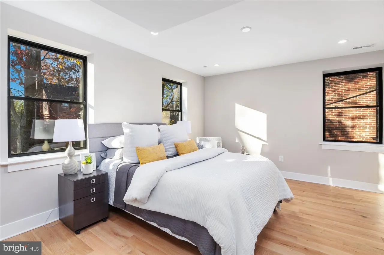 Primary bedroom with gray upholstered bed and yellow accent pillows
