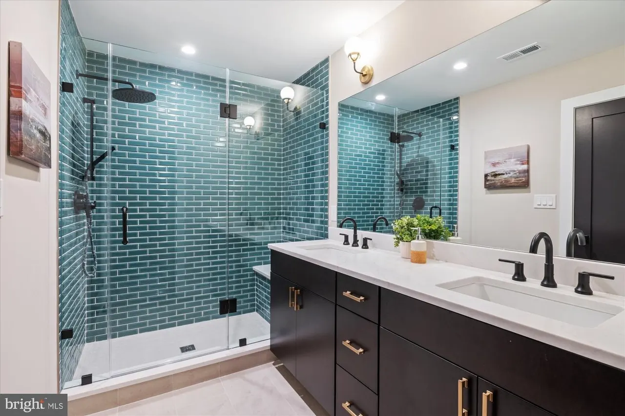 Bathroom with teal subway tile shower and black vanity