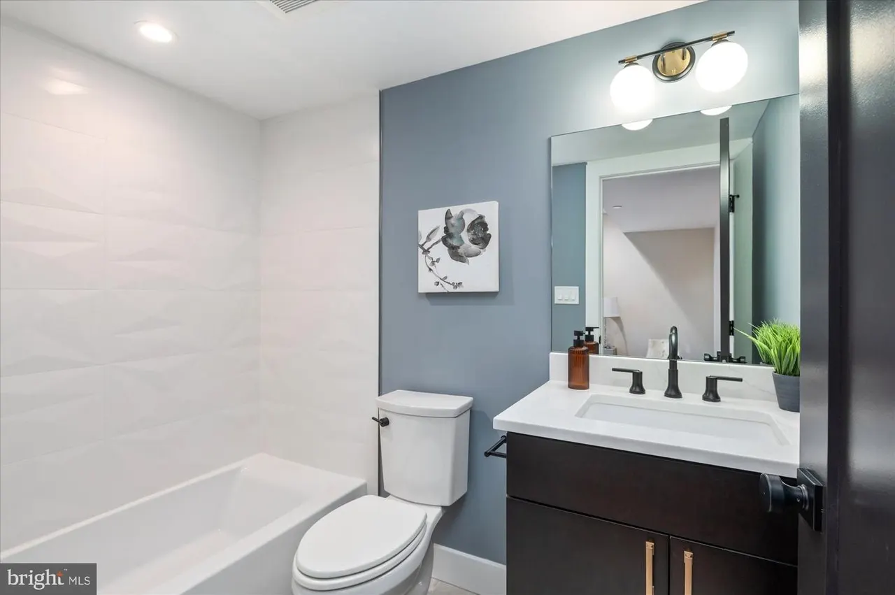 Powder room with blue accent wall and black vanity