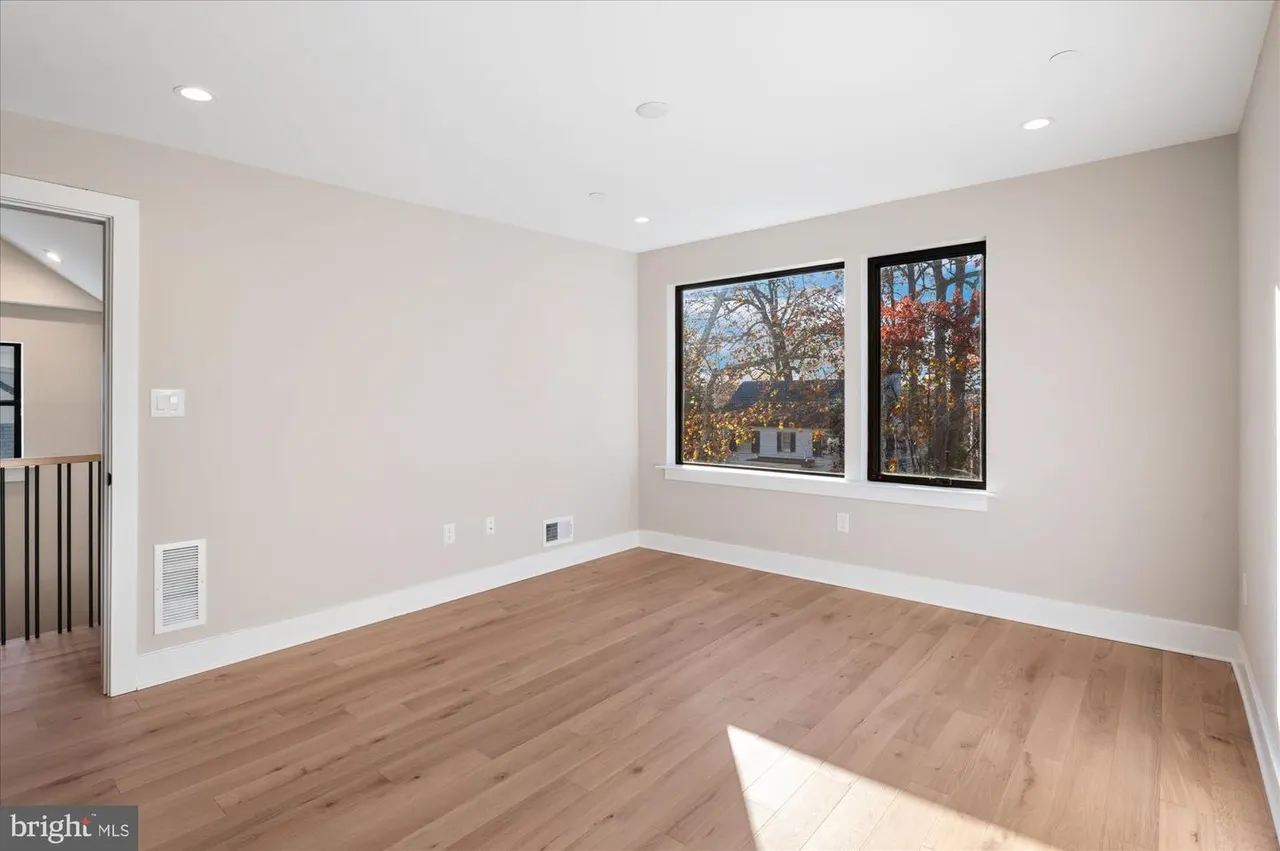 Empty room with hardwood floors and picture windows