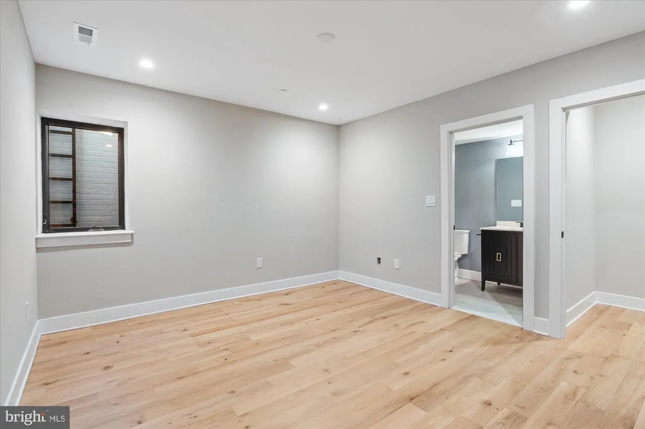 Bedroom with wood flooring and ensuite bathroom doorway