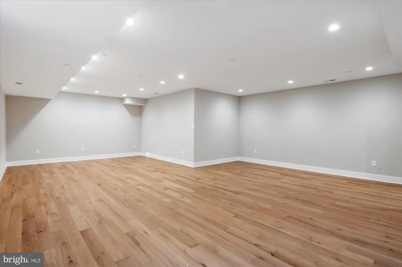 Open basement room with wood flooring and recessed ceiling lights