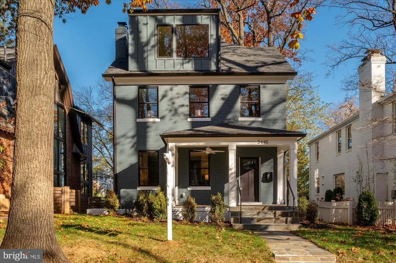 Two-story home with dormer, front porch, and mature landscaping