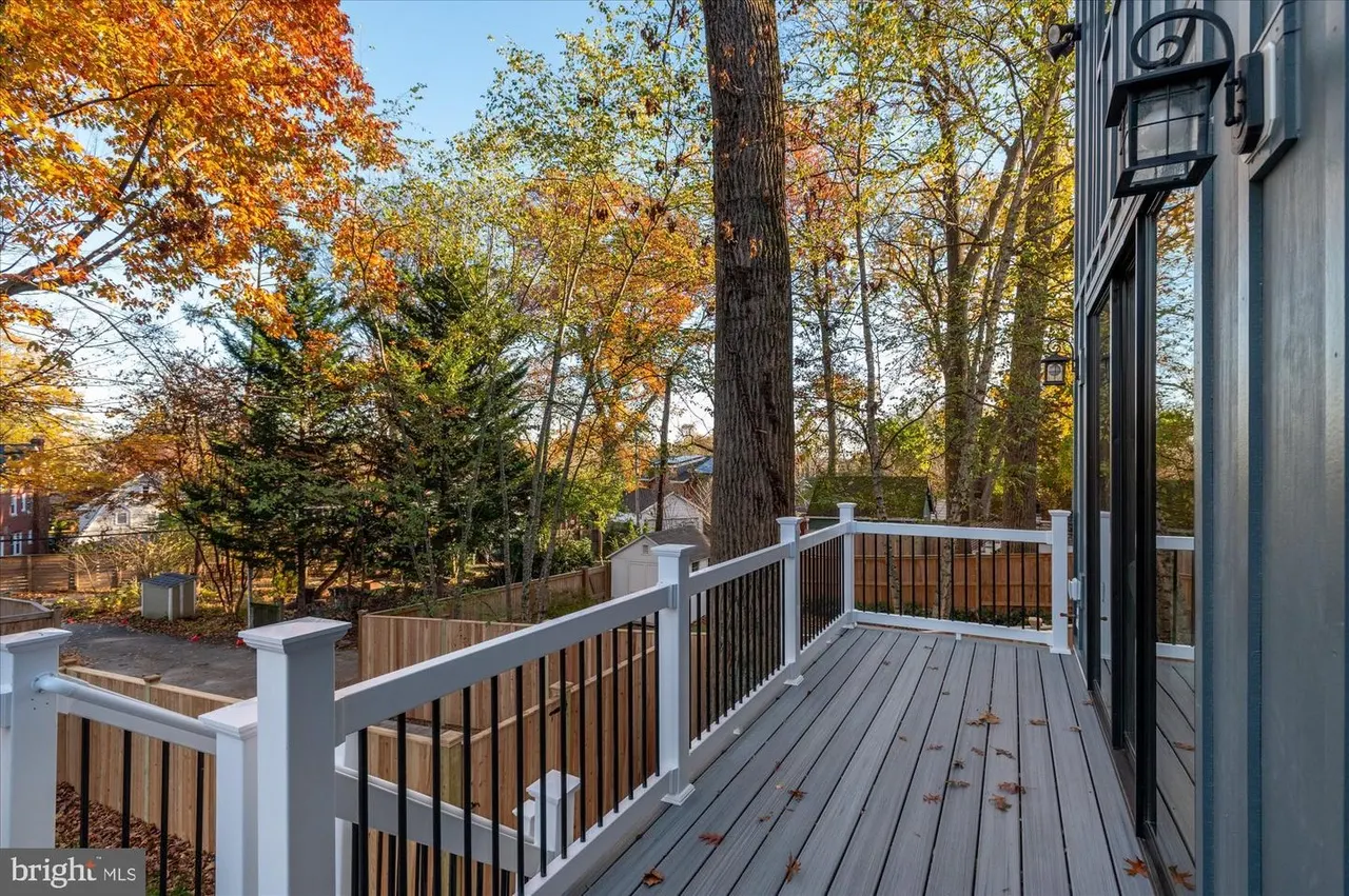 Composite deck with white and black railing overlooking wooded area