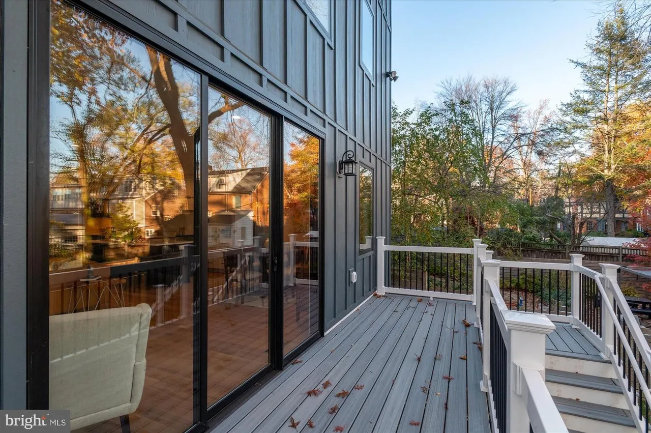 Raised deck with black sliding glass doors and metal railing