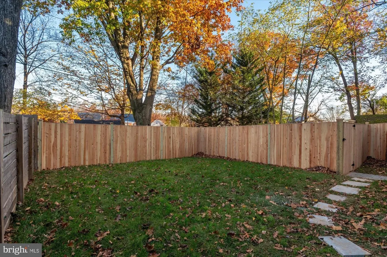 Enclosed backyard with wooden fence and stone pathway