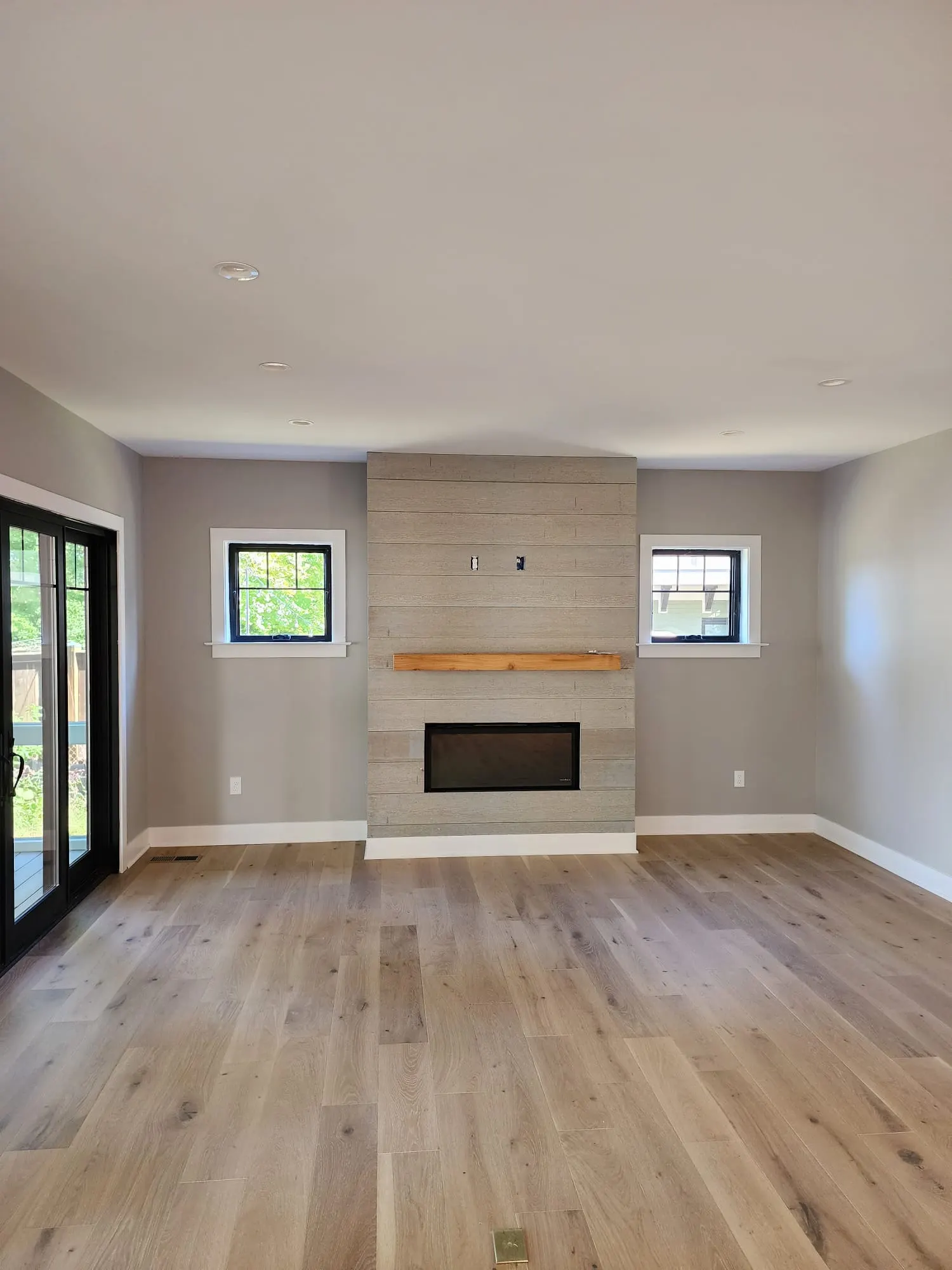 Living room with shiplap fireplace wall and wood mantel