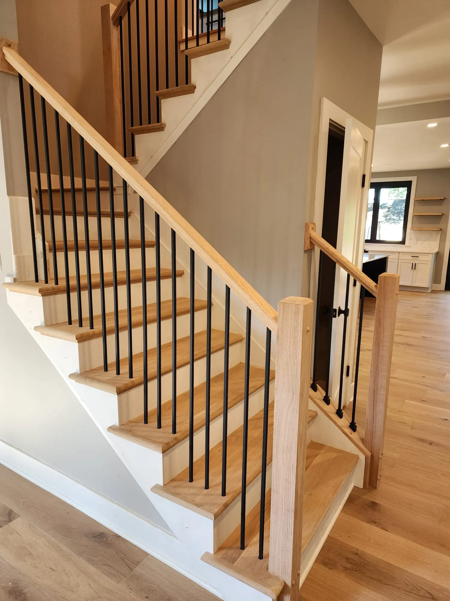 Oak staircase with black metal balusters and white risers