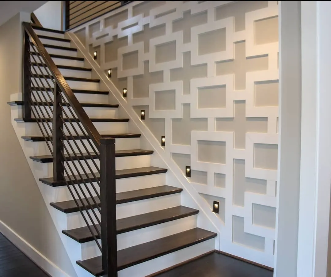 Dark wood staircase with metal railing and geometric accent wall