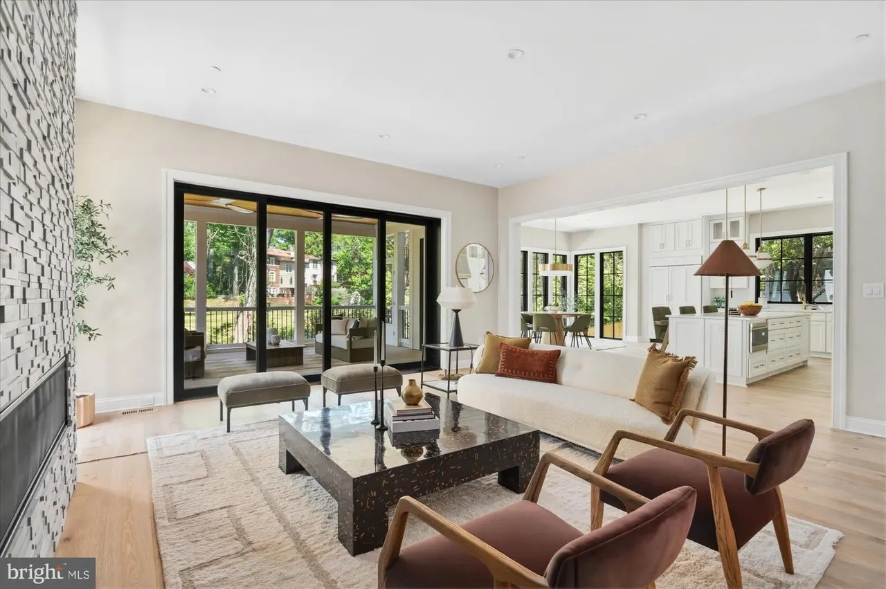 Open living room with stone fireplace and black-framed doors