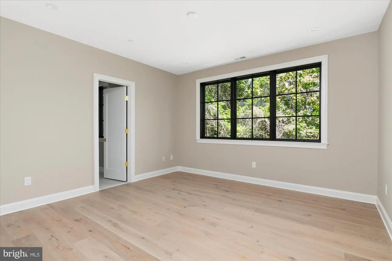 Bedroom with hardwood floors and grid-patterned window