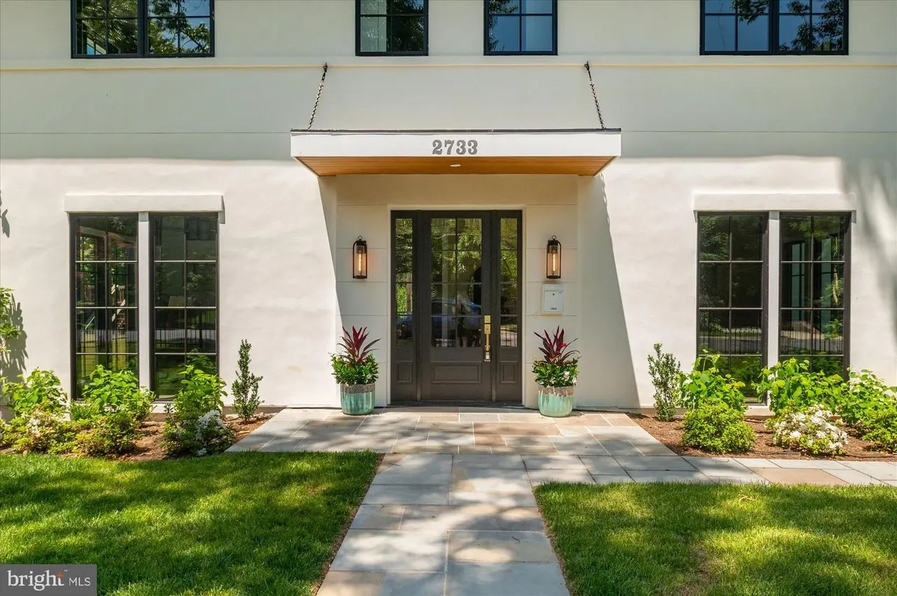 Front entrance with covered portico and landscaped flower beds