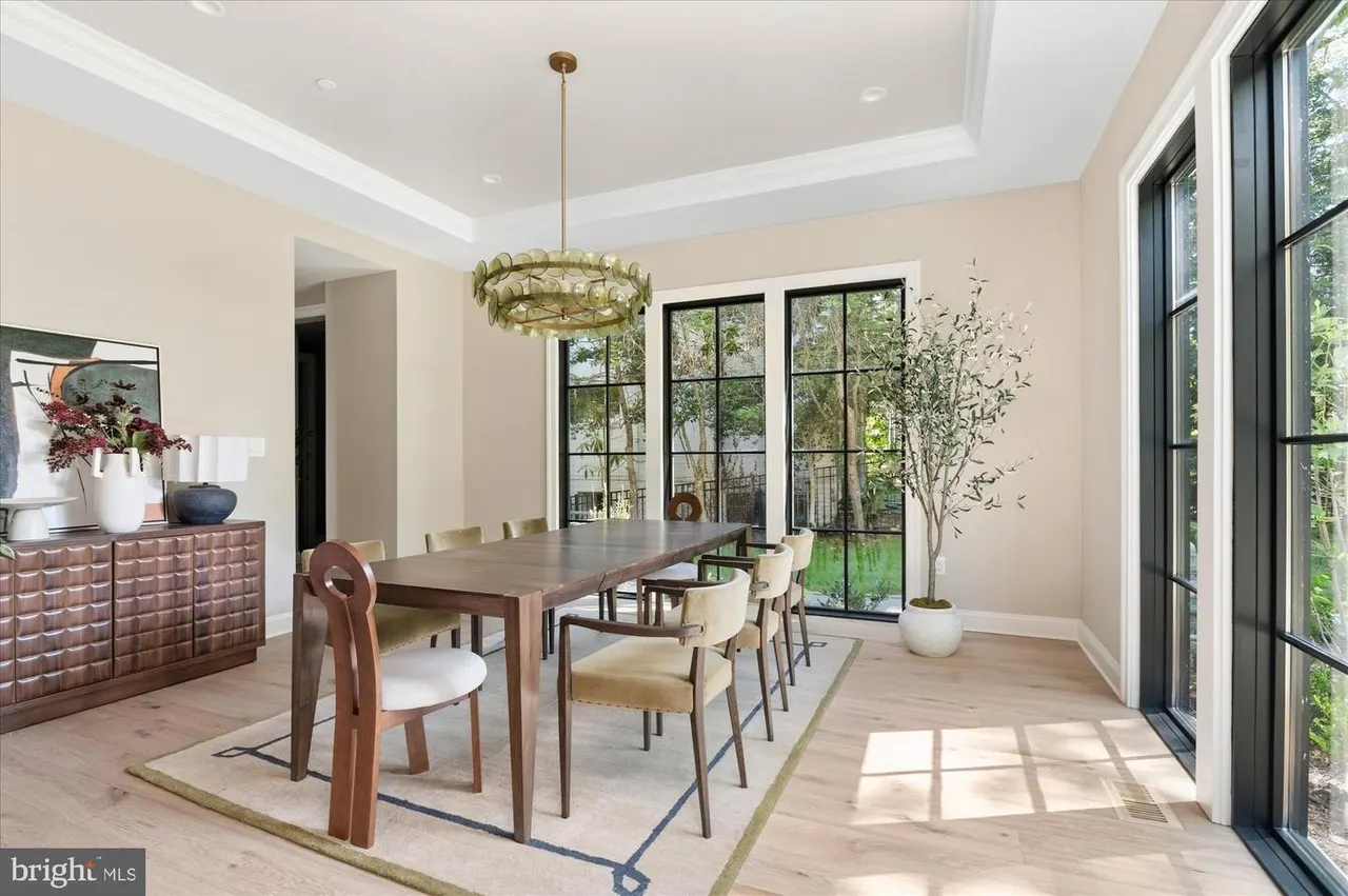Dining room with wood table, brass chandelier, and glass doors to outdoor patio
